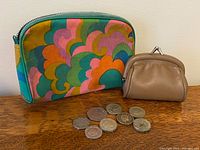 Overall lot showing zip pouch, coin purse and coins
