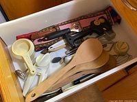 Drawer view of assorted vintage kitchen utensils