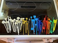 Full assortment of swizzle sticks sorted by colour on stovetop