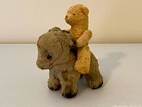 Side view of donkey with teddy bear seated on back