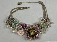 Full view of necklace showing chain, clasp, bib section, and all motifs