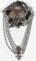 Front view of entire brooch showing floral top and chain drop