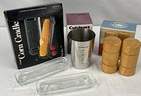 Overall lot showing Towle corn cradle box, two sample dishes, Cuisinart container with box, wooden shakers