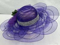 Full view of purple mesh hat showing brim shape and embellishments