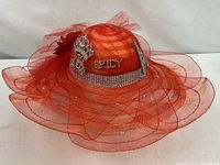 Full view of red Derby hat with layered mesh brim and rhinestone accents