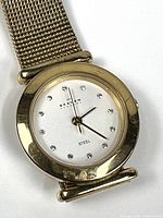 Front view of Skagen wristwatch showing dial, crystal indices, gold-tone bezel and mesh band