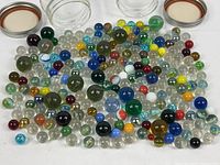 All marbles spread out with both open jars and lids visible