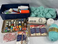 Overview of entire lot with thread cones, vintage spools, yarn skeins, packaged bias tape and macramé cord