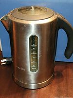 Left side view of Breville stainless steel kettle with water-level window and power cord