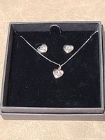 Box open showing heart necklace and earrings set