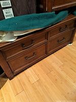 Front view of rectangular wood coffee table showing four drawer fronts and metal handles