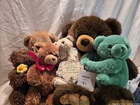 All six teddy bears grouped together, showing sizes, colors, heart plaque, ribbon, and flower accents