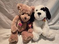 Light brown teddy bear and white puppy plush with matching scarves
