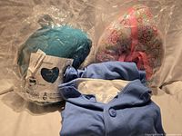 Lot overview: two packaged heart pillows and blue Jacki jacket