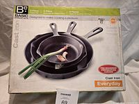 Retail box showing image of three nested cast iron frying pans and branding