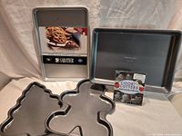 All five baking items grouped: Sabatier and Calphalon cookie sheets, two Wilton holiday pans, Fox Run cutter set