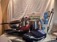 Group shot showing all cookware, colanders, sieves, broiler pan, splatter screen, chopping mats, Pfaltzgraff crock with utensils, and navy blue textile set