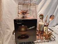 Overall lot on wire tray showing fondue pot box, utensils, napkin rings, candles, trays