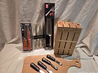 Group shot of knife block, cutting board, packaged knives and spreaders