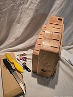 Knife block standing on cutting board with loose paring knife, steak knife, and three novelty-handle cheese spreaders displayed