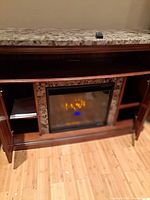 Full view of fireplace cabinet with marble top, remote visible