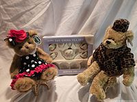 Both teddy bears seated on rattan stools beside boxed toy china tea set