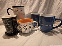 All five mugs grouped together showing designs and colors