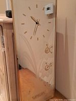 Full view of rectangular mirror wall clock showing etched floral design and gold-tone numerals