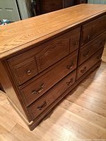 Front and side view of wooden six-drawer dresser showing drawer arrangement and hardware