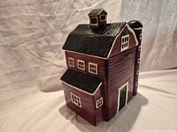 Full view of red barn ceramic cookie jar showing roof, windows, door and attached silo
