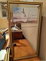 Gold-tone framed mirror showing mallard scene