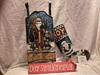 Group shot showing arched tin Santa plaque, stocking-shaped tin JOY plaque, and red Dear Santa sign