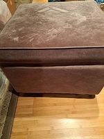 Front view of square brown microsuede ottoman showing overall upholstery and size