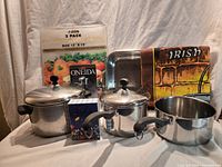 All cookware, tools, towel, sign and packaging arranged together