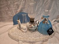 All items displayed on tray including manicure kit case, tray, unicorn figurine, oil lamp with chimney, spare chimney, and BH perfume bottle.