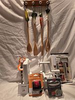 All items grouped: spiralizer, packaged peelers, wavy cutter, veggie brush, stainless peeler, wooden utensil rack, number card visible