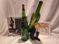 All lot items grouped: boxed wine kit, butler figurine holding bottle, two decorative bottles, ceramic trivet