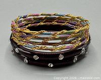 Stacked view of all six bangles showing materials and designs