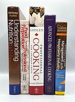 All five textbooks standing upright showing spines