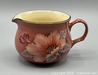 Side view of Denby Damask cream jug showing floral pattern, handle, shape, and colour