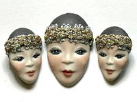 Front view of porcelain face brooch and earrings showing painted detail and trim