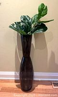 Full view of vase with foliage against wall