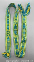 Full view of woven belt showing overall length, colors and fringe