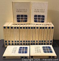 Front view of all 21 beige hardcovers showing cover design and arrangement