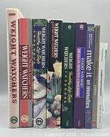 All nine books standing spine-out