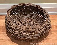Angled side view of woven basket showing rim and interior