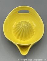 Top view of yellow ceramic juicer showing reamer, handle slot and spout