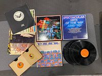 Overhead view showing boxed sets, loose LPs, album covers, and 45 sleeve