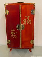 Front view showing double doors, brass hardware and Chinese characters.