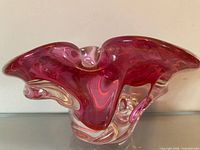 Front view of cranberry and clear freeform art glass bowl